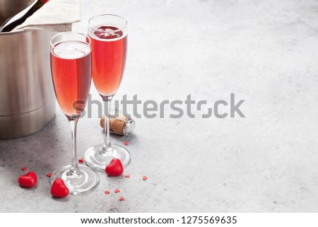 Valentine's day greeting card with champagne and heart candy on stone background. With space for your greetings