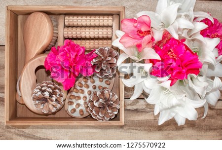 Spa treatments and massage products. Bathroom amenities, top view on a wooden table, decorated with flowers. Gift box for a woman.
