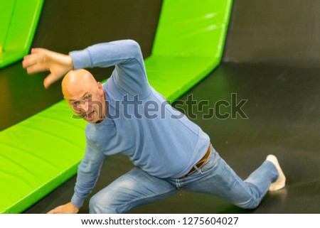 The man on a trampoline. The man fell on a trampoline. Man first time on trampoline.
