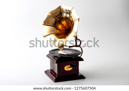 Analog sound, vintage music equipment and obsolete audio technology concept theme with old gramophone with gold and bronze horn and wooden body isolated on white background with a clipping path cutout