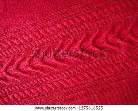 Red Knitted pattern wool sweater texture close up. Handmade red knitting wool texture background