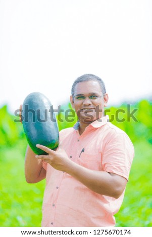 young indian farmer at watermelon field