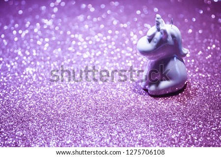 Cute pearl unicorn on a glistening purple bokeh background. Magic surreal style. Minimal composition. Copy space.