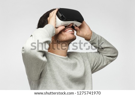 European Caucasian male wearing virtual reality headset having great fun while gaming