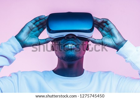 Virtual reality concept. Close-up studio portrait of african man in VR glasses  