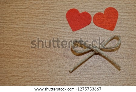 Wooden background with free copy space for text or advertisement decorated with two paper hearts and linen rope bow