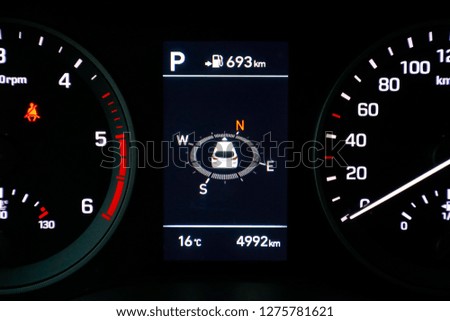 on the car dashboard with speedometer and compass indication