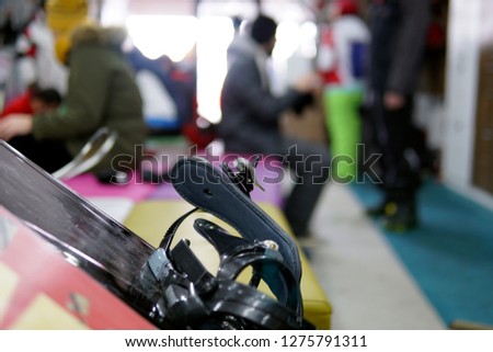 ski equipment rental room, interior, people getting dressed, shelves, boots, snowboards, skis as fun gears for winter sports