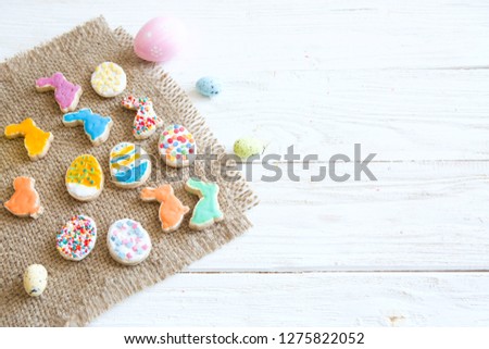 Colorful Easter cookies on a white wooden table. Eggs with different pattern icing. Top view.