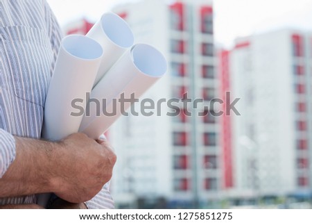 A construction worker man holding in hands blueprints