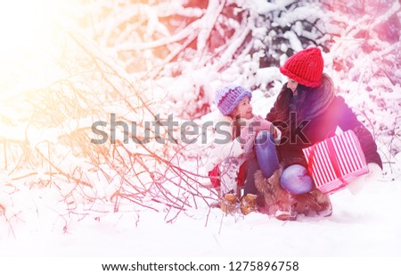 Winter fairy tale, a young mother and her daughter in the forest.