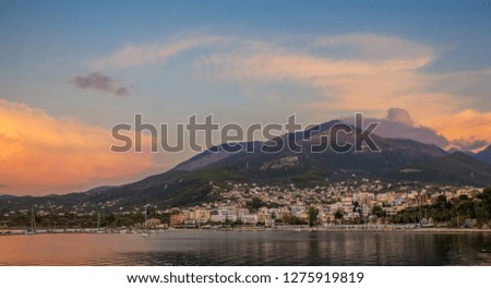 picturesque tropic sunset nature landscape photography with small south European harbor city near sea bay coast line and lonely mountain background in island in evening twilight time with colorful sky