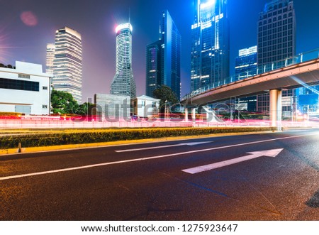 Modern skyscrapers and night car trajectories in Shanghai, China.