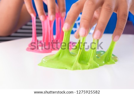 Hand Holding Homemade Toy Called Slime, Kids having fun and being creative by science experiment. Royalty-Free Stock Photo #1275925582