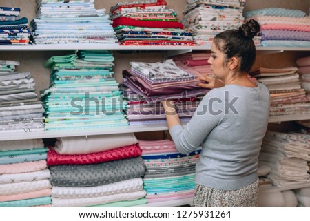 lots of bundles of different varieties of new fabric in many color collections kept on the shelf of a local store in Asia