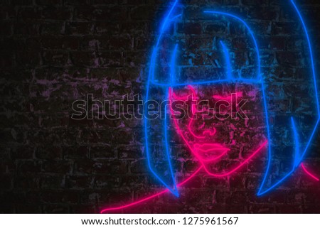 Neon female face in pink and blue lights on brick wall with copy space