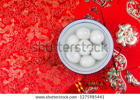 sweet dumplings in bowl on table, ang pow or red packet and gold ingots. Chinese characters means luck,wealth
 Royalty-Free Stock Photo #1275985441