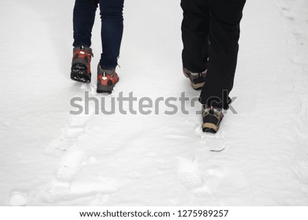 A couple walking on snow at the walk street on winter season, copy space background.