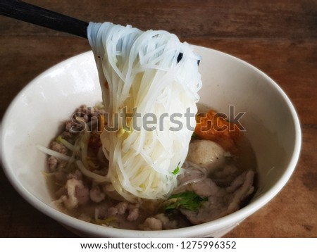 close up picture of chopsticks to pickup tasty noodles. - Image