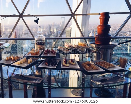afternoon high tea dessert canape buffet overlooking riyadh city in saudi arabia with a view of mamlaka kingdom tower Royalty-Free Stock Photo #1276003126