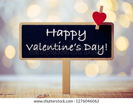 Valentine s Day greeting card. 14th of february. Happy Valentines Day Lettering written on blackboard with golden shine background. abstract background. 