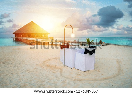 Table outdoor next to sea scenic prepare for special romantic dinner time with sunlight shading