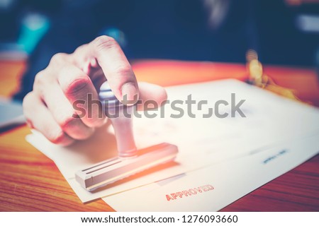Close-up hand stamping of businessman for signing approval on documents , business concept Royalty-Free Stock Photo #1276093660