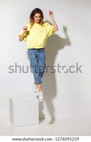 Caucasian girl wears hipster trendy clothes. Attractive woman jumping in studio