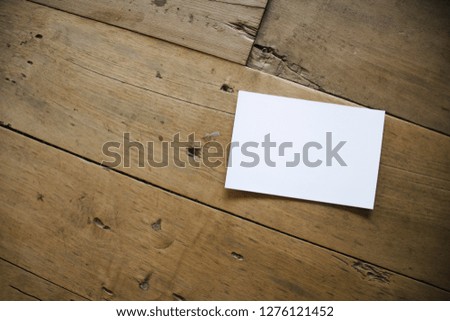 top view of white postcard or paper on old wooden background