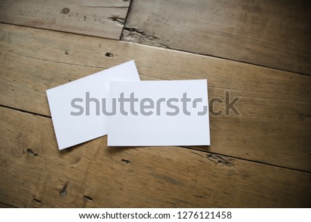 top view of white postcard or papers on old wooden background