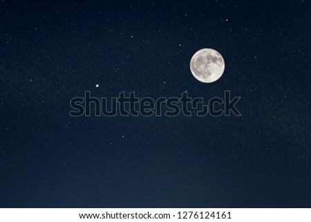 Huge full moon on the night sky with bright stars 