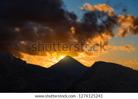 Silhouette of mountains on the sunset rainy sky background