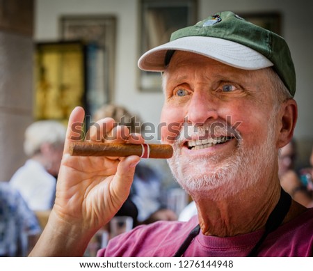 Senior tourist enjoys a freshly made cigar in Cuba