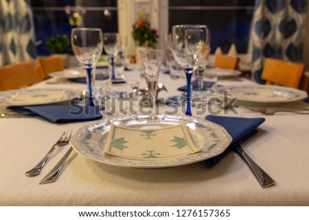 Table with porcleain dish and glasses in foreground in focus, picture from Northern Sweden.