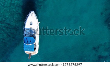 Aerial drone photo of yacht docked in tropical bay with emerald clear sea