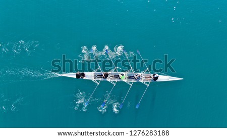 Aerial drone top down photo of sport canoe operated by team of young women in emerald clear waters Royalty-Free Stock Photo #1276283188