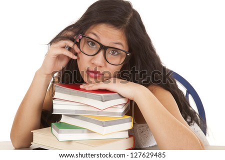 An Asian woman with her head on a stack of books.
