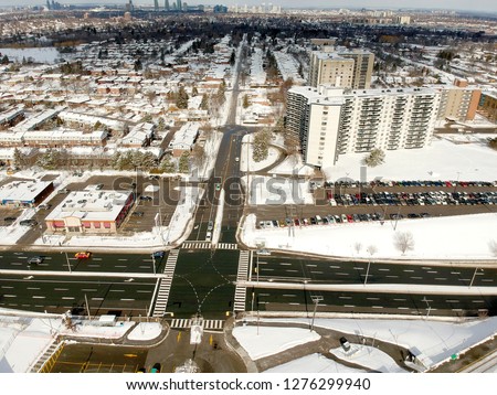 Aerial bird eye view skyline at Winter season in Canada. Hundreds of low and high rise houses from top view in the background covered in high level of snow.