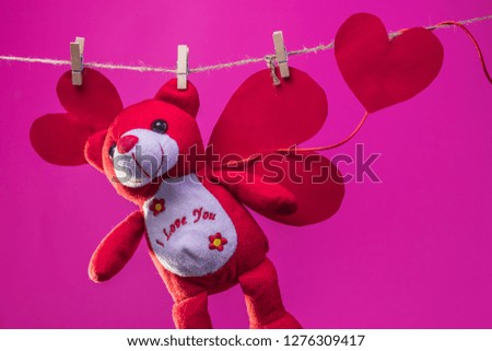 Toy Teddy bear are suspended from the rope clothespins on a background of white clouds
