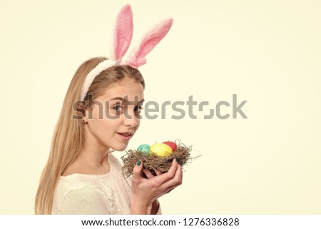Holiday celebration, preparation. Girl with painted eggs in basket, easter hunt. Smiling woman wear bunny ears on Easter day. Happy Easter concept. Festive decoration, symbol, tradition, copy space