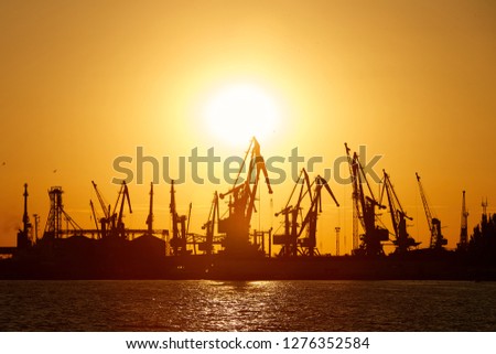 Silhouette of seaport on a background of red sunset Royalty-Free Stock Photo #1276352584