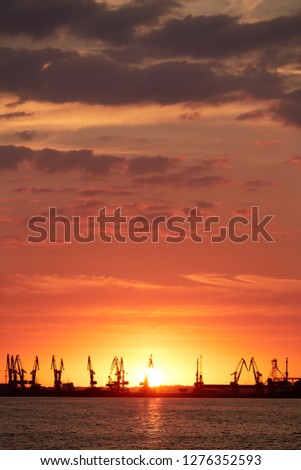 Silhouette of seaport on a background of red sunset