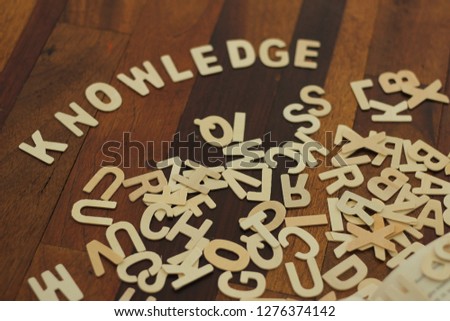 Knowledge letter created from wooden alphabet. Book with word. Education concept.