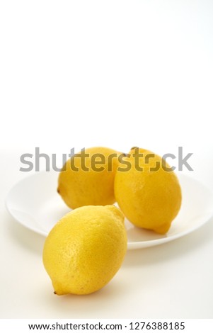 Lemons on a white plate  on a white plate with a white background and copy space