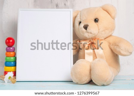 Baby toys and frame on light wall background, for design. Baby shower