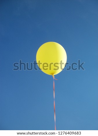 Yellow balloon against clear blue sky. Could be used for symbolism purposes. Could also be used as a joyful expression and for birthday and celebration themes. 