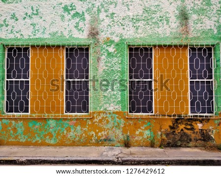 Close-up of beautiful traditional colorful old houses with decoration and metalwork on street in San Roman, Campeche, historic colonial city in Yucatan, Mexico.