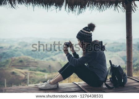 Young woman traveler using smart phone to taking photo