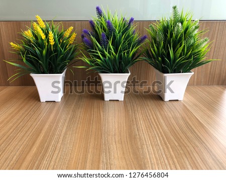flowers and green leaves for interior decoration on on wood table surface and texture background.