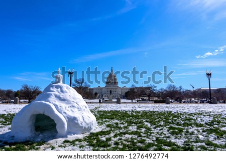 Wide angle view of Capitol Building after Snow against blue skyStorm with the igloo in foreground, Washington DC